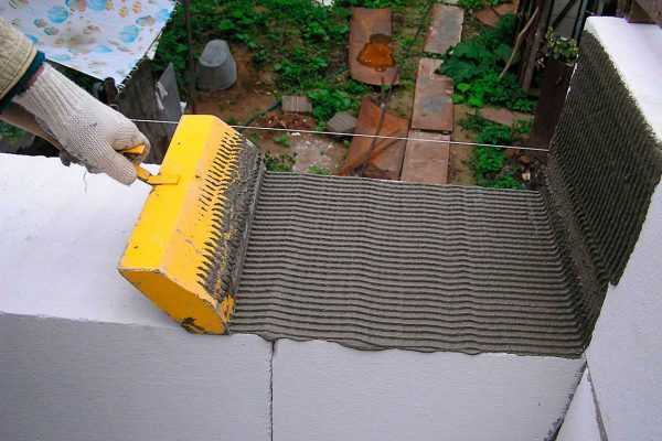 Нанесение смеси на пеноблок Укладка на клеящее средство проще чем на цементный раствор